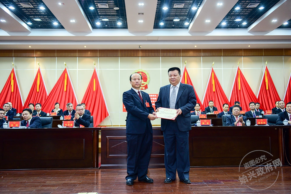 湯愛(ài)亮當(dāng)選為始興縣人民政府副縣長(zhǎng)，，圖為賴根為湯愛(ài)亮（右）頒發(fā)當(dāng)選證書(shū)