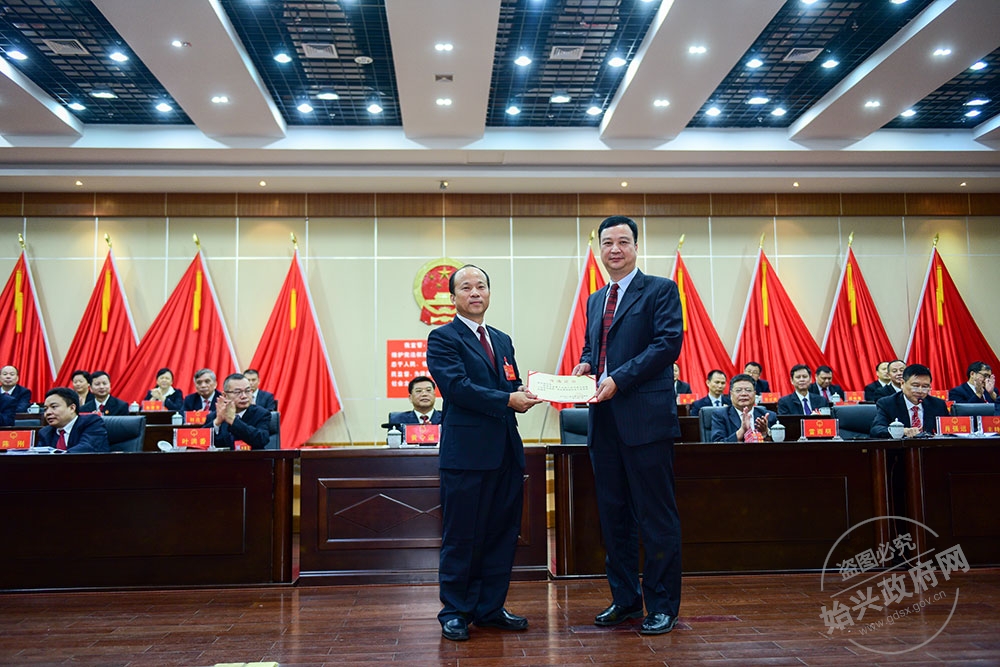 余志強(qiáng)當(dāng)選為始興縣人民政府副縣長(zhǎng)，，圖為賴根為余志強(qiáng)（右）頒發(fā)當(dāng)選證書(shū)