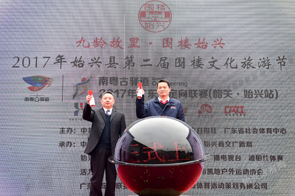 當(dāng)天上午，始興圍樓定向聯(lián)賽開賽，圖為省體育局副局長麥良和縣委書記黃建華共同鳴笛
